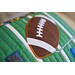 a felted football with a machine embroidered orange border on a green bench pillow
