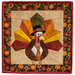 Photo of the finished foundation paper piecing block for November featuring a turkey dressed in a tie and capotain, isolated on a white background