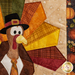Close up photo of the finished paper piecing block showing stitching and fabric details of a cartoon turkey wearing a tie and capotain