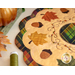 Close up photo of an applique leaf, acorns, and embroidery detail on an autumn-themed table topper