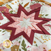 Close up of the center of the folded star design made with white, red, and yellow floral fabrics with a white center