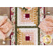 Top down image of a table runner made with log cabin blocks and cream, yellow, green, and red floral fabrics laying in the center of a table made of light wood with two place settings at each side with matching napkins