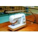 sewing machine on a desk next to an LED table lamp