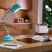 turquoise LED lamp on a desk with a tablet and book
