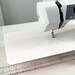 A wider shot of the sewing machine and slider in action