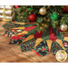 Photo of a decorated Christmas tree with an elaborate tree skirt beneath it with gold wrapped gifts in the background