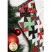 Photo of a Christmas stocking made with red, green, black, and white Christmas fabrics hanging from a white mantle with garland all around