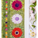 Close up photo of the border of the floral quilt showing applique details of small pink, red and white daisies with a patchwork green background hanging next to a white lattice with green climbing plants