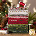 photo of pine valley fabric bundle, in warm shades of red, gray, white, and green on a wood table in front of a christmas tree