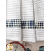 A super close up on the navy blue gingham stripe cutting across the pleats of the hanging towel.