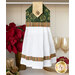 Photo of a hanging towel made with metallic green Christmas fabrics hanging on front of a white shelf containing a poinsettia, gold dishware and winter decor items