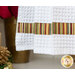 Close up photo of the bottom of a hanging towel made with metallic striped Christmas fabrics hanging on front of a white shelf containing a poinsettia, gold dishware and winter decor items