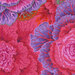 Close up of Fabric featuring vibrant pink and purple cabbages accented by orange and mint green cabbage leaves