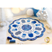 Photo of the finished table topper for January featuring blue mittens radiating around the center circle on a pale countertop with winter decor and matching thread spools all around