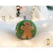 Photo of a wool felt ornament featuring a gingerbread man, surrounded by white Christmas and winter decor.