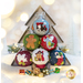 Photo of an evergreen shaped box filled with felt ornaments stacked inside and surrounded by white Christmas and winter decor.