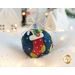 Photo of a wool felt ornament featuring a Christmas stocking filled with goodies, surrounded by white Christmas and winter decor.