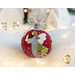 Photo of a wool felt ornament featuring the profile of a small angel with holly on their dress and holding a candle, surrounded by white Christmas and winter decor.