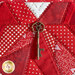 Close up of the center of the project showing stitching detail and red fabrics with an antique key charm at the center.