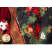 Photo of a winter themed panel quilt featuring a panel with red cardinals and poinsettias on a black background with a rustic textured border, draped over a ladder with winter decor on one side.
