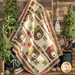 The Paddling Bears quilt, draped and staged with little evergreen saplings and camping paraphernalia.