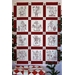 The completed Here Comes Santa quilt, staged with pine saplings. 