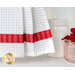 Close up photo of a hanging kitchen towel made with red, white and aqua fabrics in the foreground of a shelf filled with kitchen items like assorted jars.