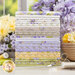 taupe, cream, yellow, green, and purple floral fabrics, stacked on a wood table in front of a window and purple and yellow flowers