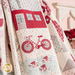 Close up of the draped quilt, showing fabric and stitching details on a block with an applique bicycle and fish pond.