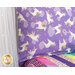 A close-up of the pillow on the bed, showing details of the purple fabric with white unicorns.