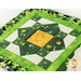 A close up on the patchwork square, a lovely green, cream, and gold arrangement of squares.