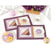The two completed Tea & Cookies placemats for May, colored in rich purples, gold, and cream, staged on a white table with white teacups and coordinating cookies. A basket of purple flowers peeks into frame from above.