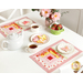 The June placemats in action,  staged on a white table with a teapot, full teacups, butterfly shaped cookies, and a jar of coordinating pink flowers.