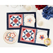 A top down shot of the completed July placemats, staged with white teaware and plates holding patriotic star cookies.