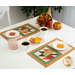 The two mats in action, each holding a white plate with a coordinating leaf shaped cookie on a white plate.