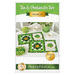 Front cover of the pattern, showing the two completed placemat sets in green and gold, staged on a white table with plates of shamrock cookies, coordinating green house wares, and flowers.