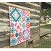 Image of another sample quilt, in white, pink, orange, and teal.