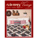 Front cover of the magazine, in deep crimson red and showing a log cabin quilt on a bed, staged with coordinating decor and a very cute corgi dog on the bed.