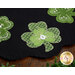 A close up on one of the shamrocks, showing wool, embroidery, and embellishment details.