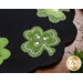 A close up on one of the shamrocks, showing wool, embroidery, and embellishment details.