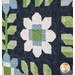 A close up on one of the floral blocks at a slight angle, showing fabric and quilting details on a white patchwork flower.