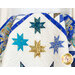 A shot of the draped quilt, showcasing four of the sawtooth stars against the white sashing.