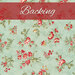 A light teal blue fabric with tossed red florals and green leaves and vines. At the top, a soft red banner reads 
