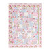 Photo of a finished pink, blue, white, and green floral quilt isolated on a white background