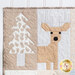 A close up on the first blocks of a tree and a deer peeking out in neutral fabrics.