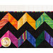 A shot of the top of the quilt showing fabric and stitching details as well as demonstrating contrast between the black and rainbow fabrics.