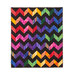 The completed Charming Chevrons Quilt in contrasting black and rainbow fabrics, isolated on a white background.