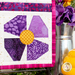 A super close up on the lower right block of the wall hanging, showing piecing and top quilting details on the purple posy. Coordinating flowers and decor peek in from the right side of the image.