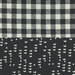 Fabric split into two sections: one with white quotes on a black background, the other a black and white check pattern.