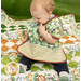 A very sweet baby sitting on top the Little Pathways Quilt in Wee Safari, modeling the toddler bib, demonstrating scale and size.